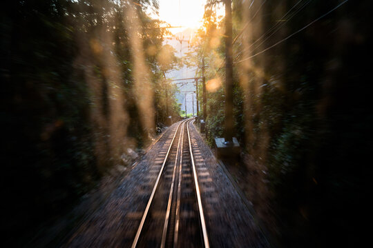 Sun flare peaks out on the tracks of a railroad