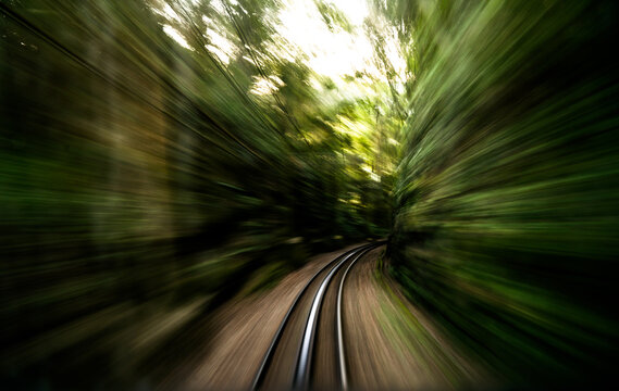 Sun flare peaks out on the tracks of a railroad