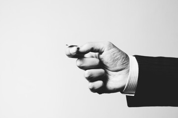 Hand of a business man in suit about to toss a coin.