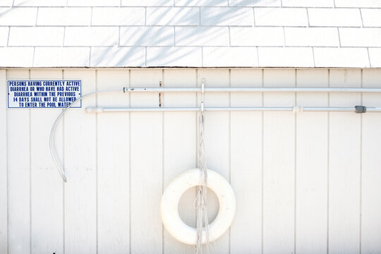 Pool warning sign on white wall.