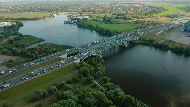 Cinematic view on traffic on the bridge. Highway over bay. Shadow. From drone. Summer day. Top view. High quality 4k footage shooting from drone