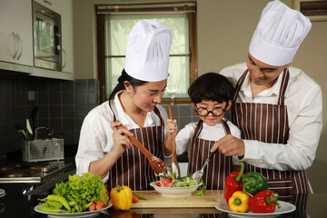 Happy family Father , Mom and Son help to make salad