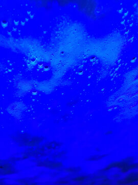 Close up of soapy water on car windshield with blue light