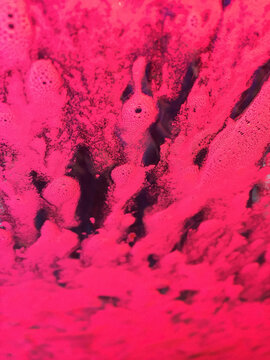 Close up of soapy water on car windshield with red light