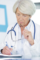 woman as senior doctor writing notes