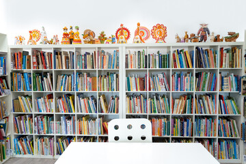 Russia Moscow 25.09.20 Children's city library. Special reading kids room with bright ceramic figures, toys. Many shelves, bright interesting, educational books about animals,fairy tales.Table, chair - Powered by Adobe