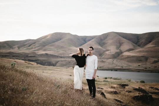 modern fashionable couple standing in desert landscape
