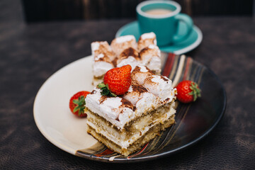 Homemade Tiramisu cake a traditional Italian dessert with strawberries on a dark background