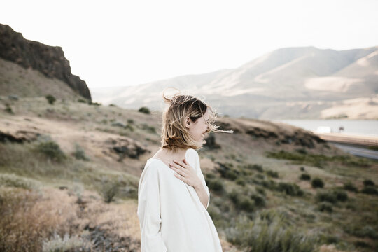 young woman holding hand on chest laughing in desert