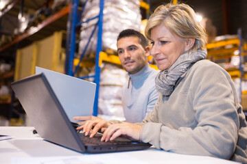marketing professional using laptop in the warehouse