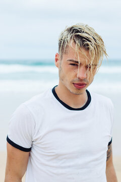 Handsome young man with wet hair on the beach