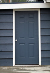 old blue door with white trim and blue shingles