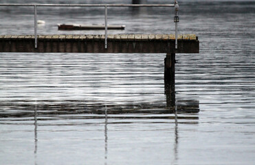 Docks reflected in calm and rippled water on the shoreline