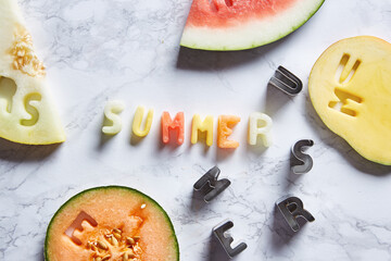 Summer fruit letters on table with slices of fresh exotic fruit