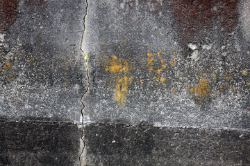 Abstract shot of cement shoreline wall with cracks and colored patches for background