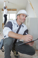 engineer using clipboard to write something while working indoors