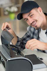 happy young man fixing a printer