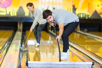 man and wman cleaning bowling alley