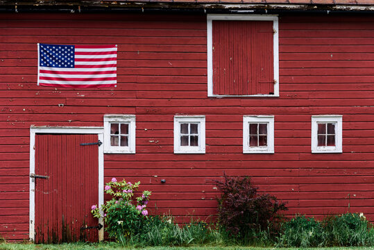 side of an old red barn with american flag,
