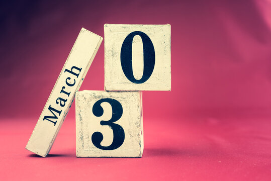 March 30th, Thirtieth of March, Day 30 of month March - vintage wooden calendar blocks on maroon background with empty space for text