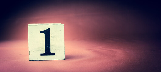 Old vintage wooden block with digit 1, number one - vivid maroon background