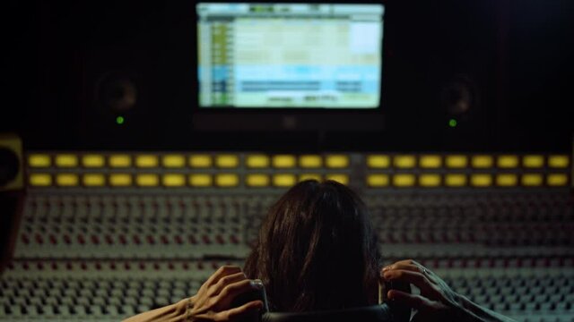 Musician listening music indoor. Sound producer working in recording studio.