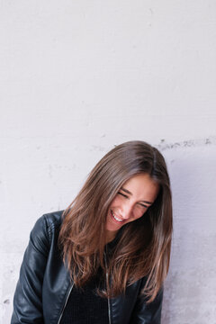Smiling beautiful brunette against of white wall