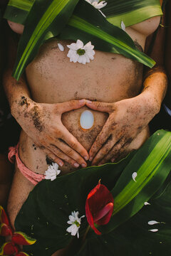 Beautiful naked female body covered with tropical flowers and plant