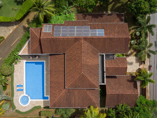 Aerial drone view of luxury tropical villa with solar panels on the roof, pool and palm trees, Las...