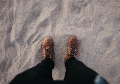 standing with brown boots looking down at ground human perspective