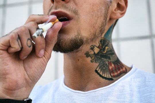 Close-up of tattooed man smoking cigarette