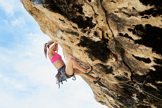 Sportswoman climbing the cliff