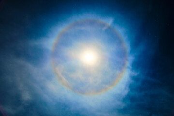 Super moon with a circular rainbow halo formed by the mist Bblue foggy night with diffused...