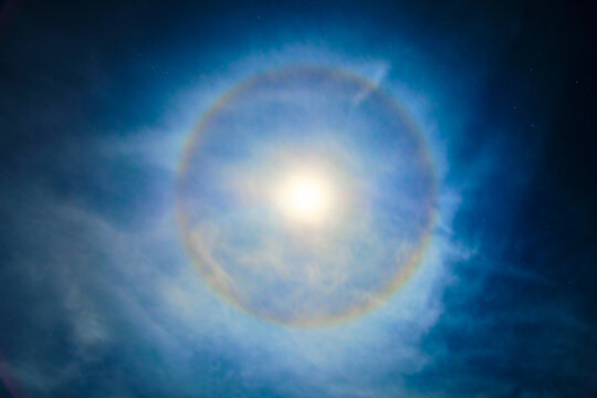 Super moon with a circular rainbow halo formed by the mist Bblue foggy night with diffused moonlight and stars