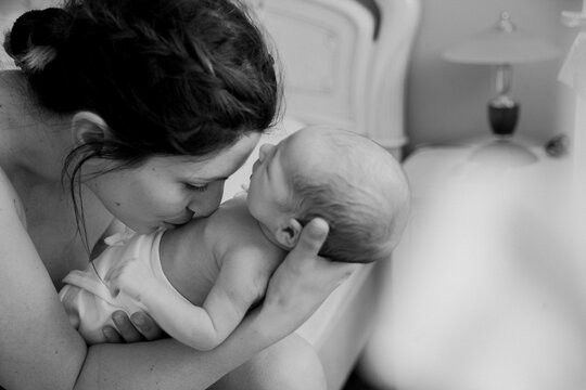 Mother holding and kissing her baby