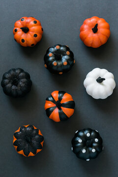Assorted decorated pumpkins on black.