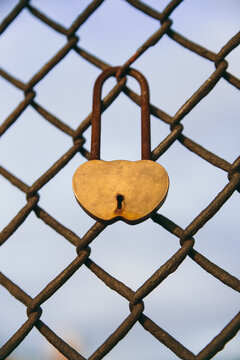 Old metallic lock on fence with shape of a heart