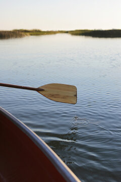 A Canoe Paddle Against A Calm Lake On A Summer Morning