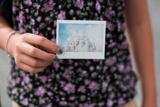 Young woman holding instant photo