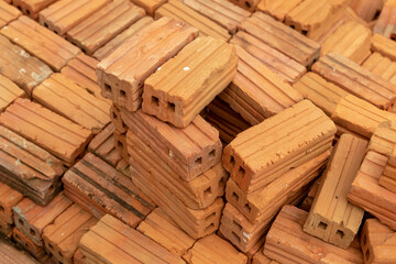 stack of new rectangular bricks red with two holes background construction