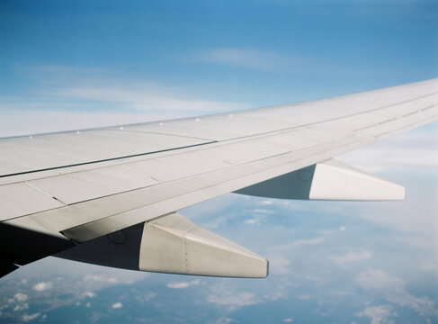 Wing of airplane flying above the clouds.