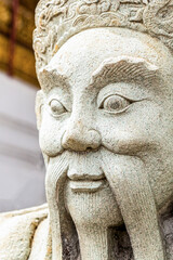 sculpture of an ancient warrior with large and long whiskers of white stone close up