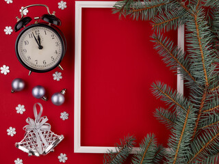 Christmas-New year red horizontal background.Pine branches lie on a white frame,along with a vintage alarm clock and Christmas decorations.Space for text.2021