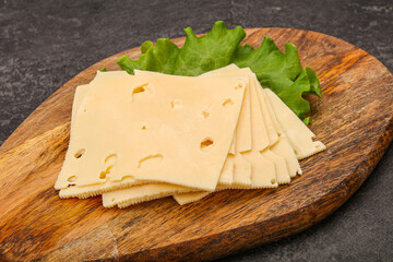 Sliced yellow cheese over board