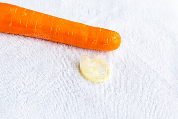 safe sex symbol, set carrots and condom close-up lies on a white background