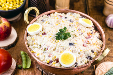copper pot with vegetarian food, typical mayonnaise from Brazil, with tomatoes, potatoes, eggs and fruit