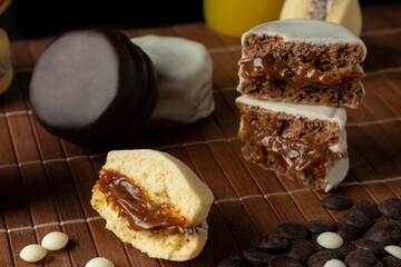 
Artisanal alfajores of cornstarch with coconut, white chocolate and dark chocolate with dulce de leche on wooden mat