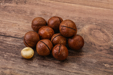 Brown macadamia nut heap over background