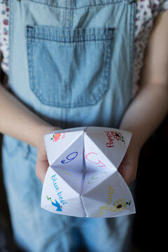 A girl with an Origami Fortune Teller paper game