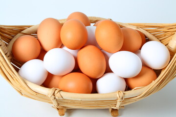 Fresh brown and white eggs in basket